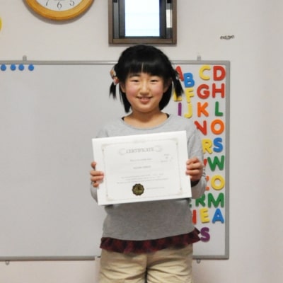 ２０１９年度の英検ジュニア・ゴールド級の結果証明書を持っている生徒ちゃんの写真