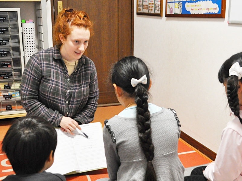Otisの英会話教室の先生が２０２２年の３月に子供レッスンの生徒ちゃん達と宿題の予習をしている時の写真